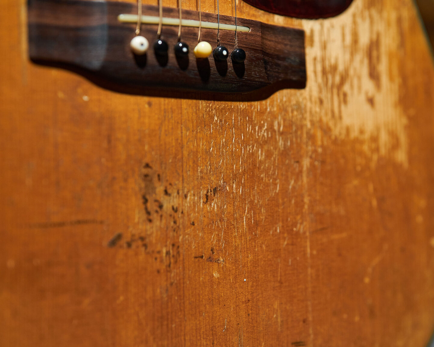 Closeup photo of the bridge of an acoustic guitar